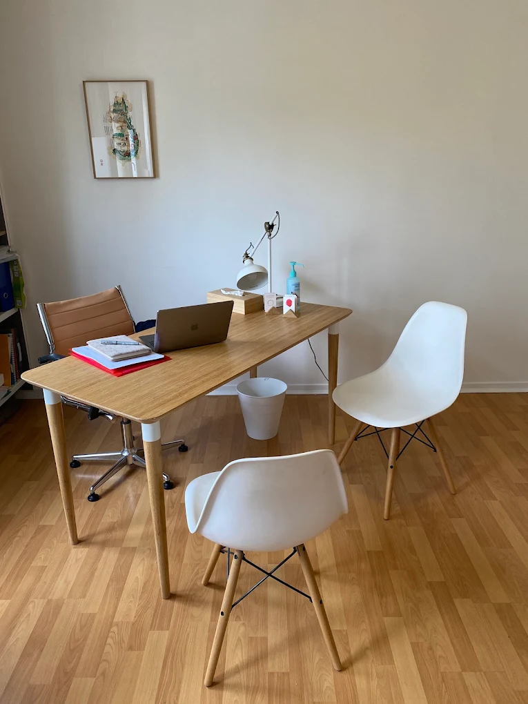 Le bureau du cabinet de sophrologie à Lyon 9 : table en bois, fauteuils et lampe d'appoint