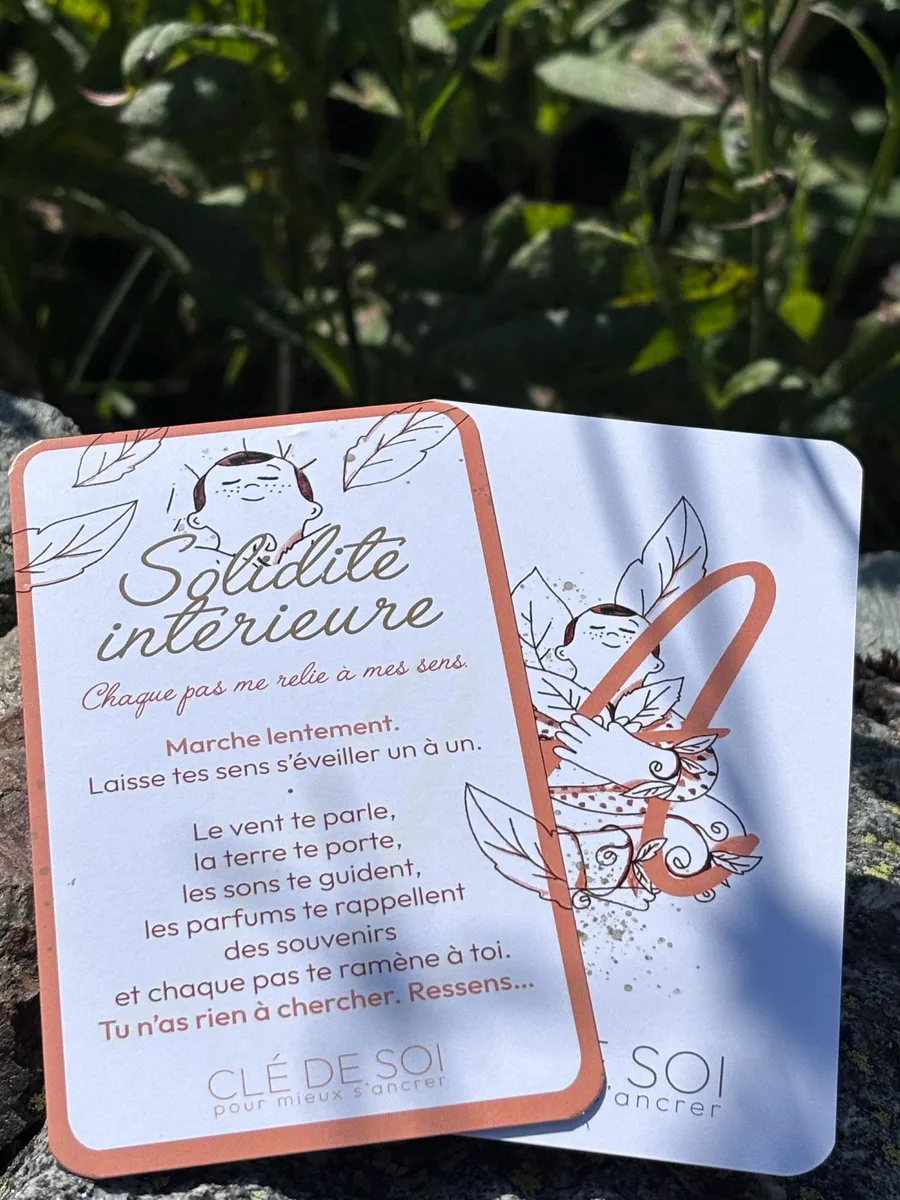 La carte d’ancrage « Chaque pas me relie à mes sens », posée dans la verdure