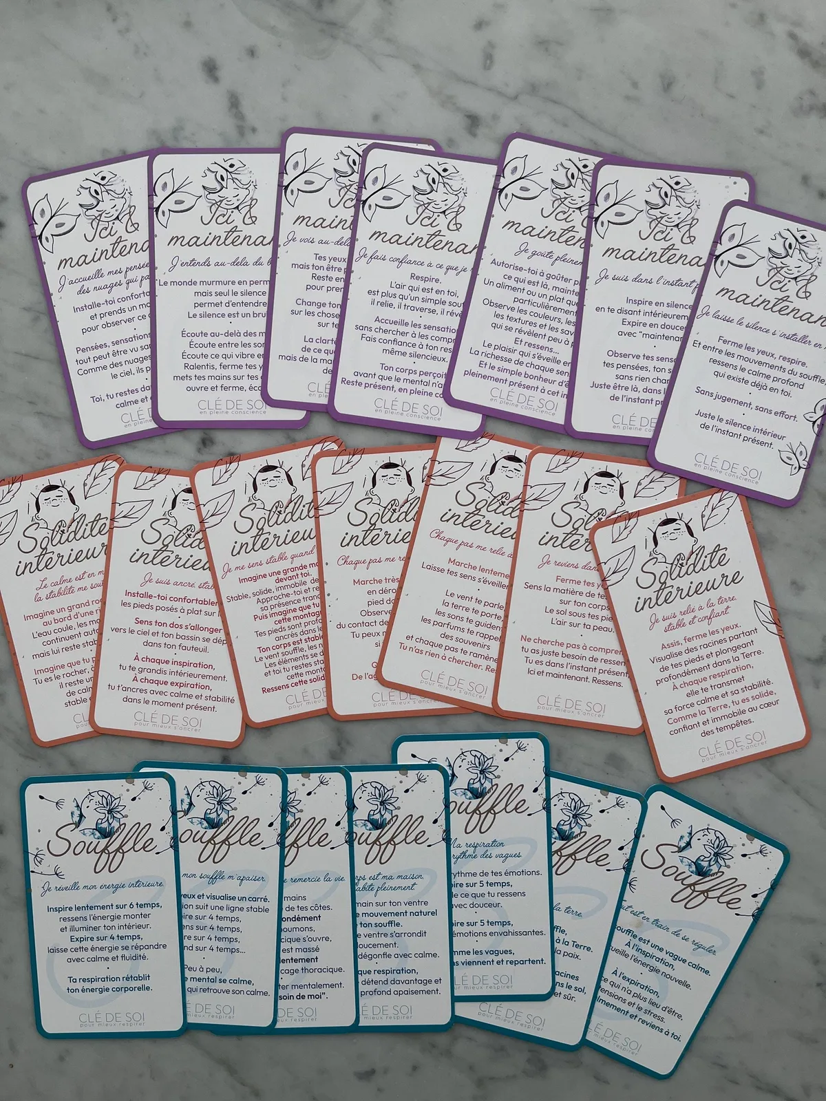 Les 21 cartes du jeu Clé de Soi étalées en trois rangées : Souffle en turquoise, Solidité intérieure en abricot, Ici & maintenant en violet